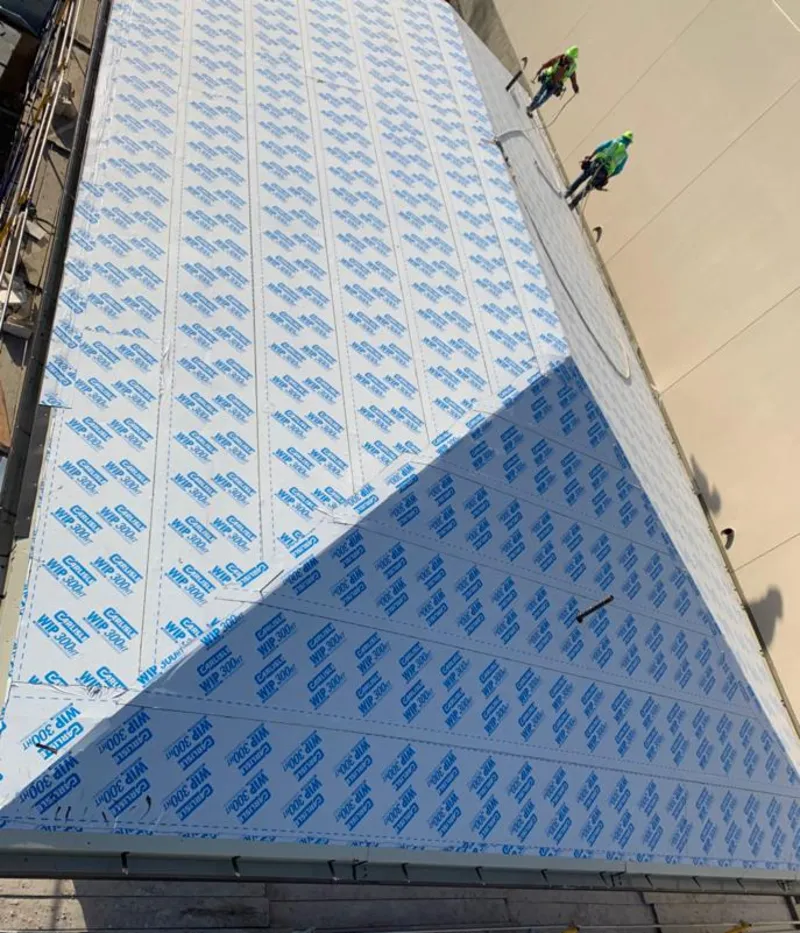 Professional roofers installing underlayment on a metal roof in Four Corners